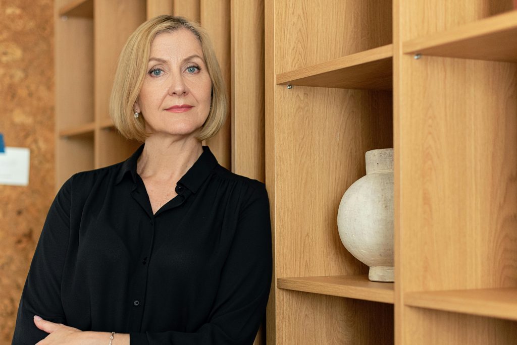 Confident businesswoman standing in an office setting, showcasing leadership.